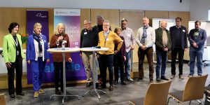 Sabine Meck (3. v.r.) dankt und ehrt die ehrenamtlichen Mitarbeitenden mit einer Urkunde, Blume und einem Geschenk