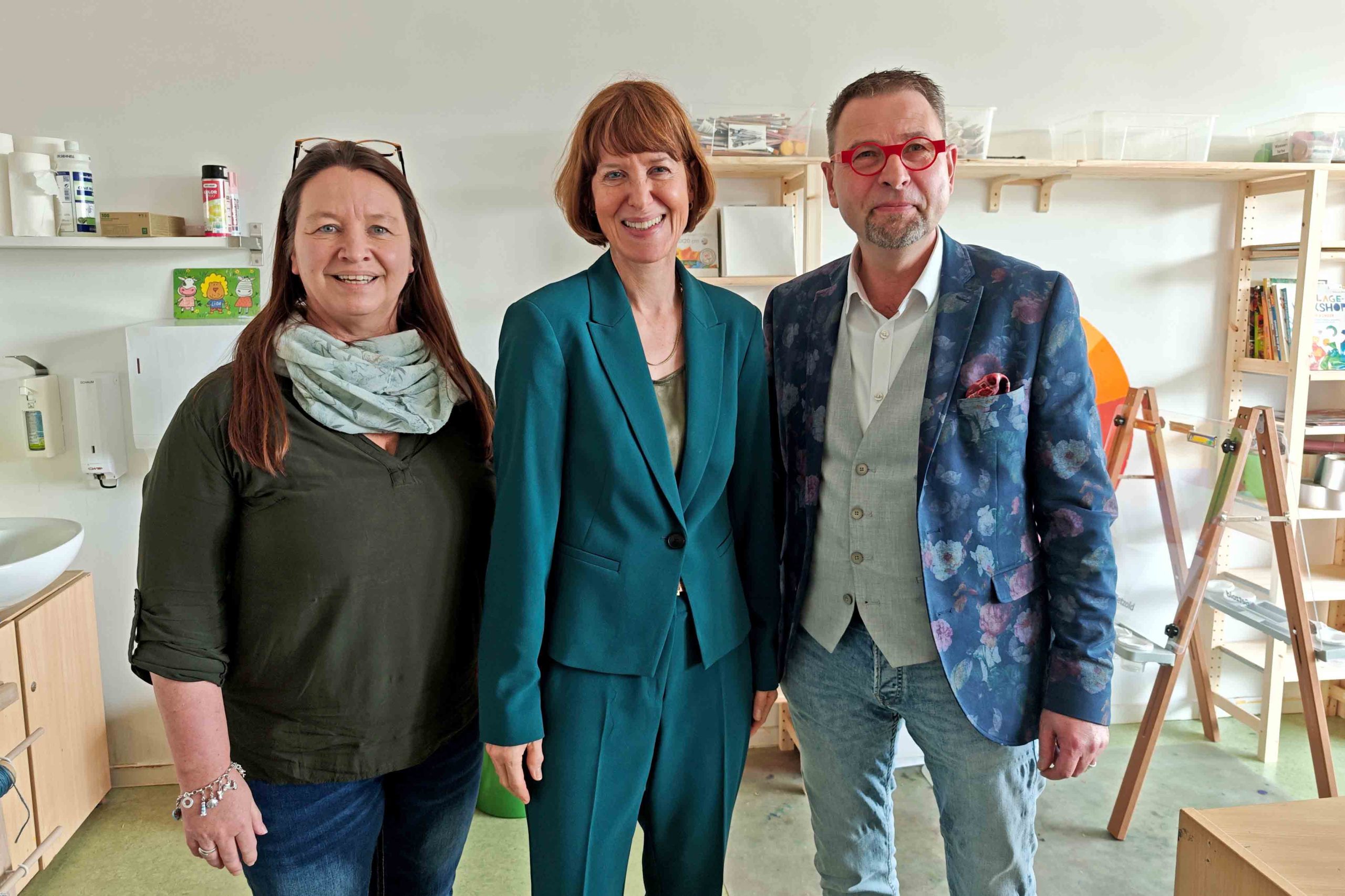 Kita-Leiterin Annette Buchmann, Sozialministerin Heike Hofmann und Carsten Baumann, Geschäftsführer des Fachbereichs Evangelische Tageseinrichtungen für Kinder im Evangelischen Regionalverband Frankfurt und Offenbach, in der Kita Riedberg. 